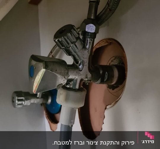 ברז מתכת עם צינור גמיש מתחת לכיור
